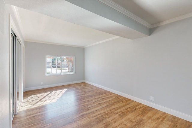 spare room featuring ornamental molding and light hardwood / wood-style flooring