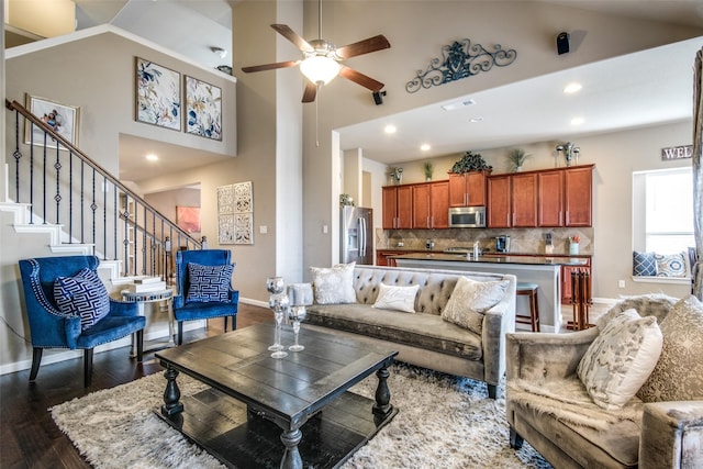 812 Green Coral Dr, Little Elm, TX 75068 - living room featuring baseboards, ceiling fan, dark wood-style flooring, high vaulted ceiling, and stairs