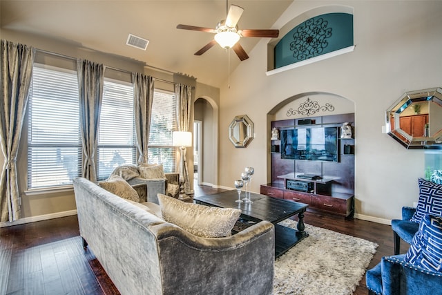 living room featuring dark wood-type flooring, ceiling fan, and high vaulted ceiling