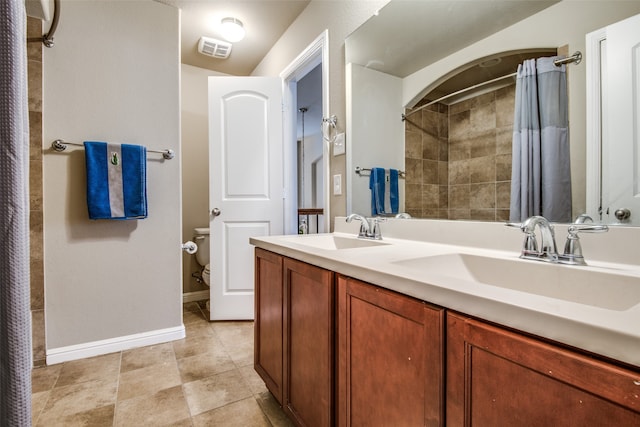 bathroom with walk in shower, vanity, toilet, and tile patterned flooring