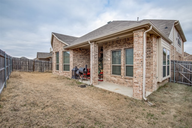 back of property featuring a yard and a patio