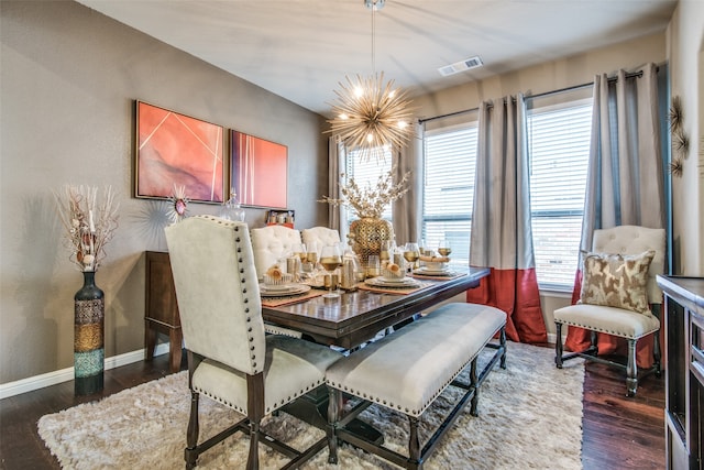 dining area with a wealth of natural light, dark wood-type flooring, and a notable chandelier