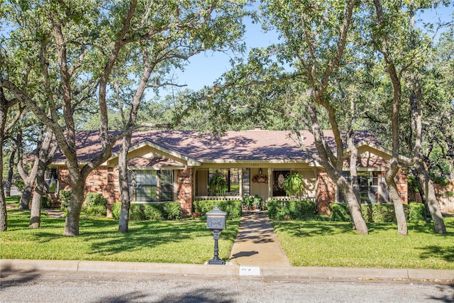 ranch-style home with a porch and a front yard