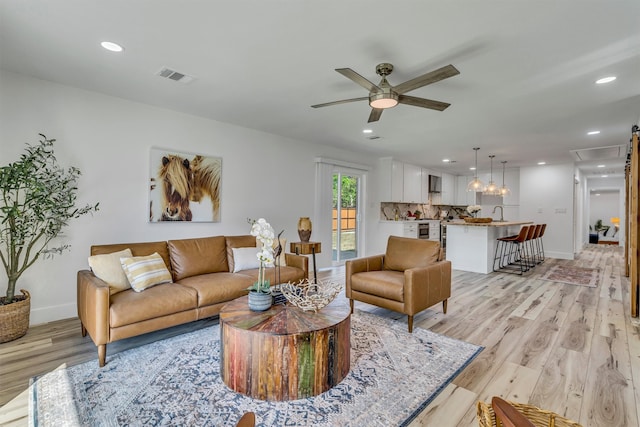 living room featuring light hardwood / wood-style floors and ceiling fan