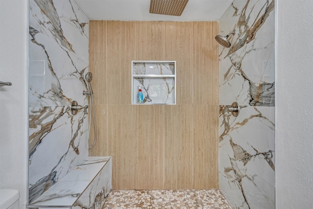 bathroom with tiled shower and toilet