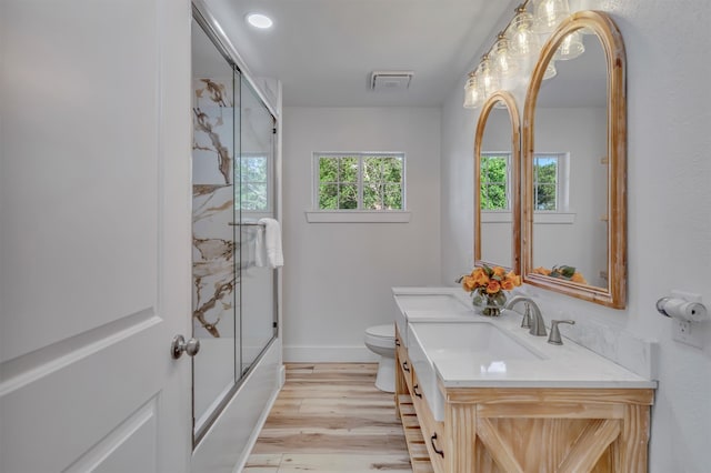 full bathroom featuring shower / bath combination with glass door, wood-type flooring, toilet, and vanity