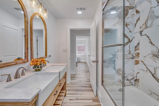 bathroom featuring combined bath / shower with glass door, vanity, and hardwood / wood-style flooring