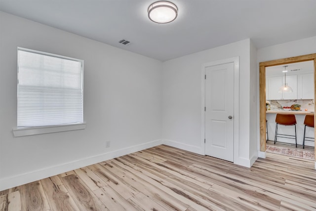 empty room featuring light hardwood / wood-style floors and built in desk