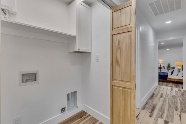 laundry area with cabinets, washer hookup, and light wood-type flooring