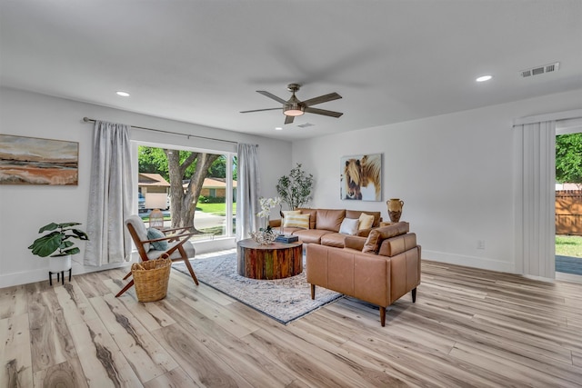 living room with light hardwood / wood-style floors and ceiling fan