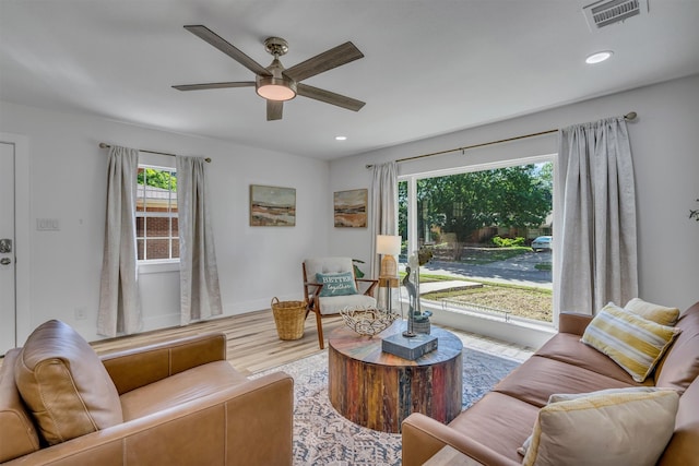 living room featuring wood-type flooring and ceiling fan