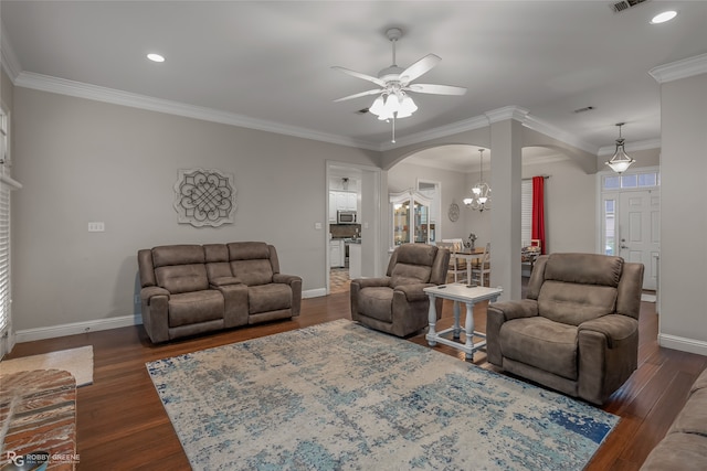 living room with ceiling fan with notable chandelier, ornamental molding, and dark hardwood / wood-style floors