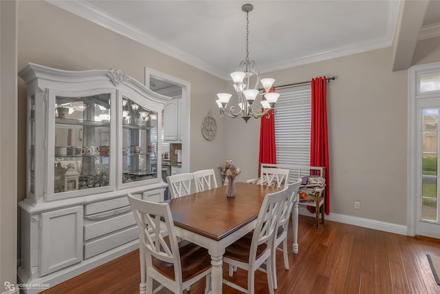 dining area featuring dark wood-type flooring, crown molding, and an inviting chandelier