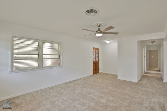 unfurnished room featuring ceiling fan, light carpet, and ornamental molding