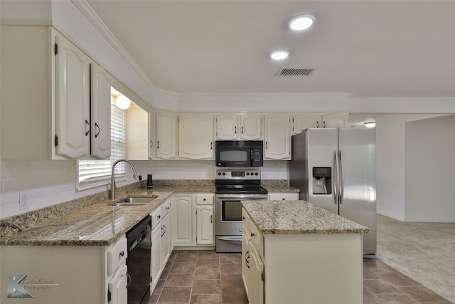 kitchen featuring black appliances, sink, light stone counters, and a center island