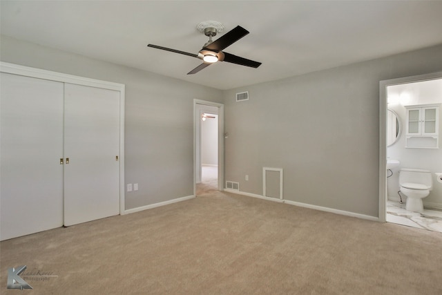 unfurnished bedroom with ceiling fan, connected bathroom, light carpet, and a closet