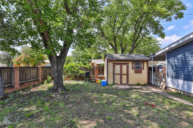 view of yard with a storage shed, an outbuilding, and a fenced backyard