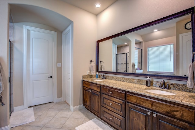 bathroom featuring tile patterned flooring, vanity, and a shower with door