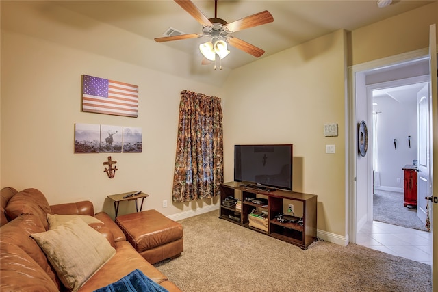 carpeted living room with ceiling fan and vaulted ceiling