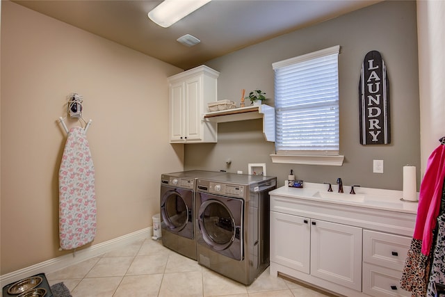 washroom featuring cabinets, light tile patterned floors, washer and dryer, and sink