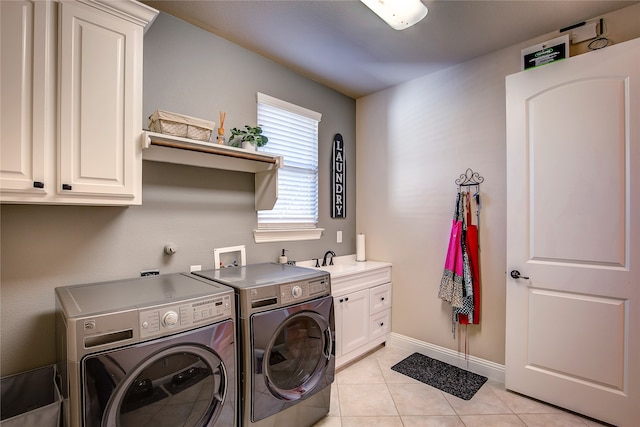 washroom featuring sink, light tile patterned floors, cabinets, and independent washer and dryer