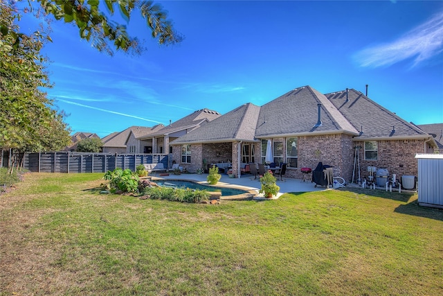 back of house with a yard and a patio