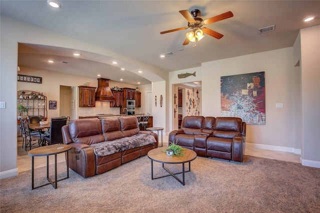 living room featuring ceiling fan and light colored carpet