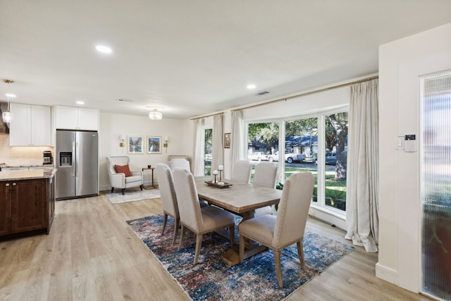 dining space featuring light wood-type flooring and a healthy amount of sunlight