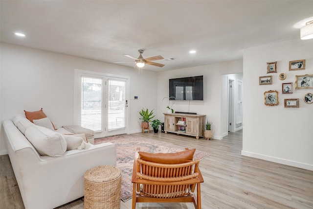 living room with ceiling fan and light hardwood / wood-style floors