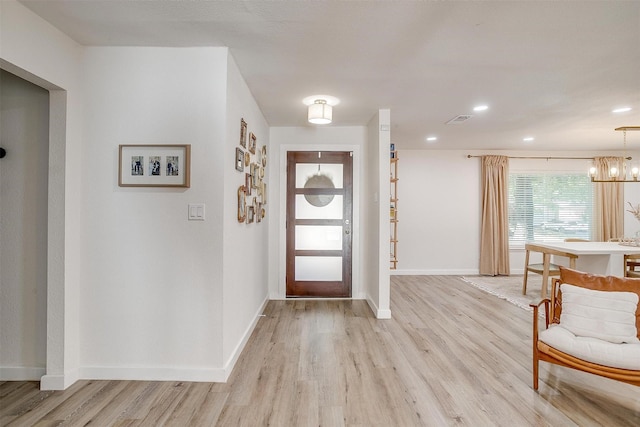 foyer entrance featuring a notable chandelier and light hardwood / wood-style floors