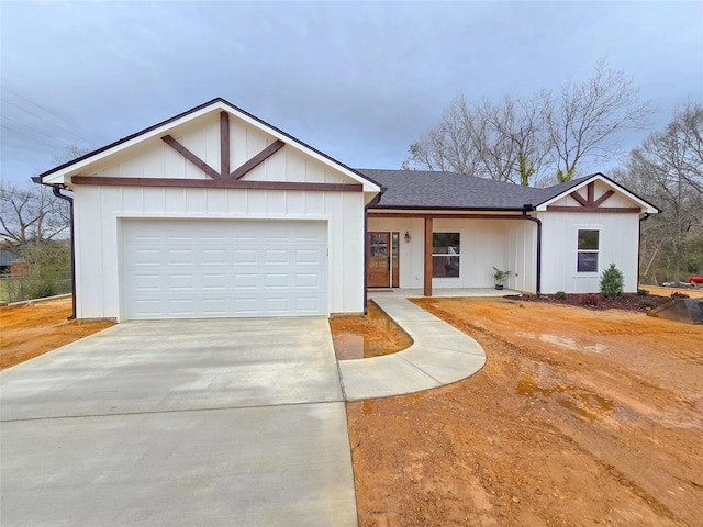 view of front of house featuring a shingled roof, concrete driveway, and an attached garage