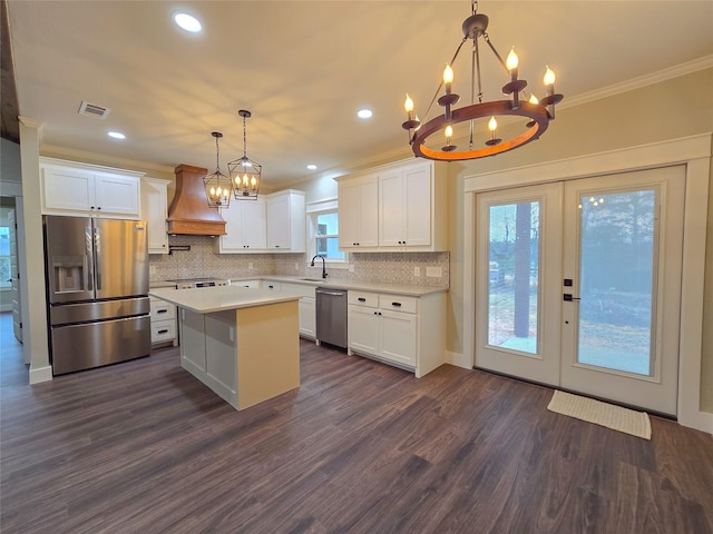 kitchen with light countertops, appliances with stainless steel finishes, custom exhaust hood, and white cabinets