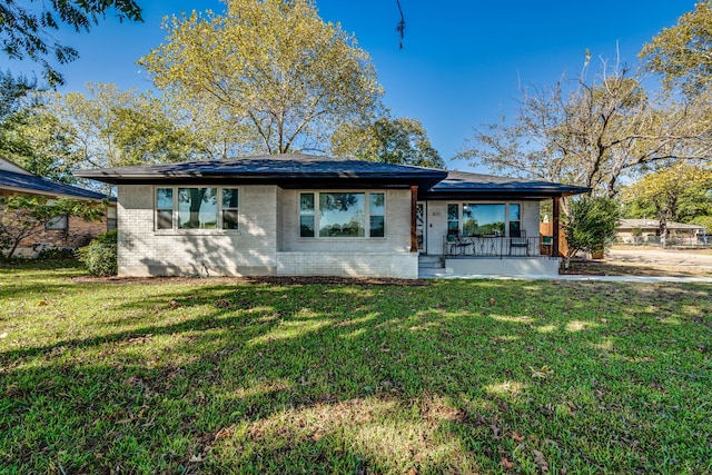 back of property with a lawn and covered porch