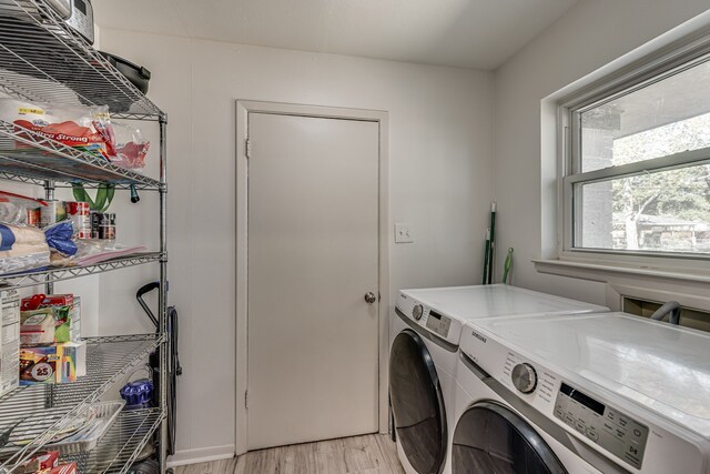 laundry area with independent washer and dryer and light hardwood / wood-style flooring