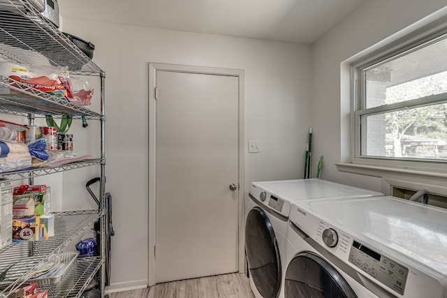 laundry area with independent washer and dryer and light hardwood / wood-style flooring