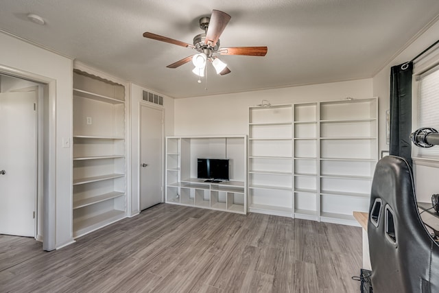 unfurnished living room with a textured ceiling, wood-type flooring, and ceiling fan