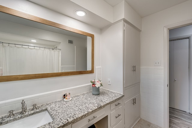 bathroom featuring tile walls and vanity