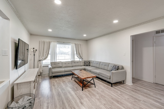 living room featuring a textured ceiling and light hardwood / wood-style flooring