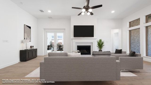 living room featuring light wood-type flooring and ceiling fan