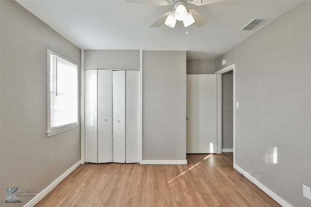 unfurnished bedroom with ceiling fan, light hardwood / wood-style flooring, and a closet