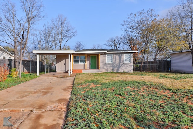 ranch-style house featuring a front lawn and a carport