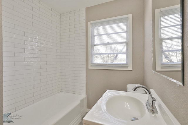 bathroom with vanity, plenty of natural light, and tiled shower / bath