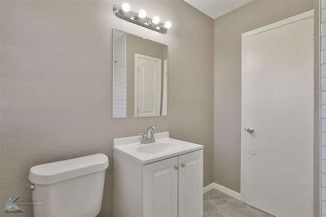 bathroom featuring toilet, tile patterned flooring, and vanity