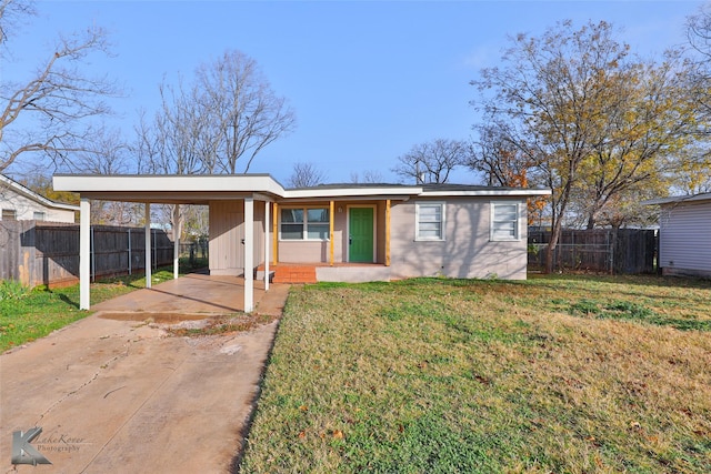 view of front of house with a carport and a front lawn