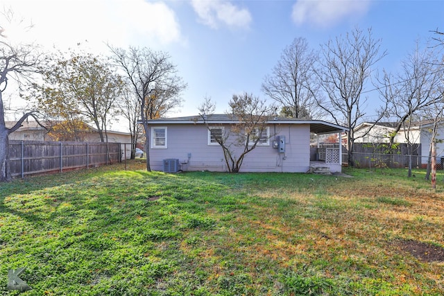 back of house featuring central AC and a yard