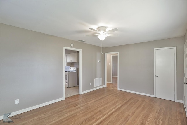 unfurnished bedroom with ensuite bathroom, ceiling fan, and light hardwood / wood-style floors