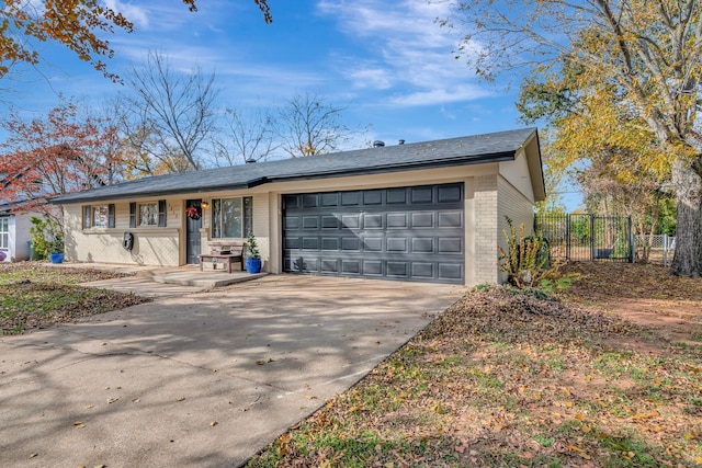 ranch-style house with a garage, concrete driveway, brick siding, and fence