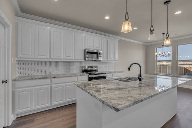 kitchen featuring pendant lighting, a kitchen island with sink, sink, white cabinetry, and stainless steel appliances