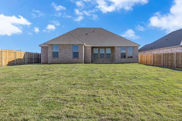 rear view of property featuring a yard