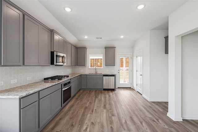 kitchen featuring backsplash, appliances with stainless steel finishes, sink, and gray cabinetry